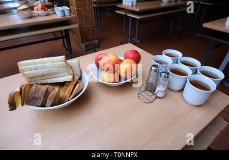 In corrispondenza di una chow hall, parte del soldato cena: tabella insieme con il pane, mele su piatti e tazze di tè. Novo-Petrivtsi base militare, Ucraina. Nov 12,2018 Foto Stock