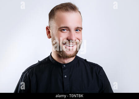 Ritratto di un bel giovane uomo sorridente su sfondo grigio Foto Stock