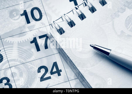 Il concetto di business. Blocco note, calendario e penna a sfera. Meccanismo di orologio sfondo. Foto Stock