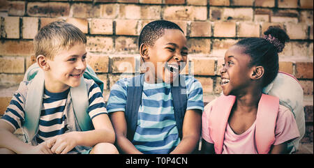 Felici i bambini seduti sui gradini Foto Stock