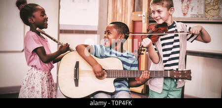 Bambini che giocano gli strumenti musicali in aula Foto Stock