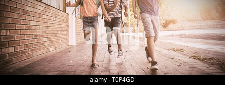 Felici i bambini della scuola in esecuzione in corridoio Foto Stock
