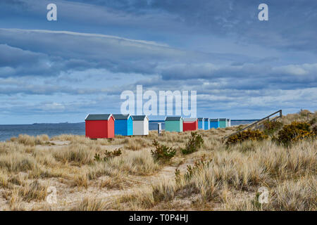 FINDHORN BEACH Moray Firth Scozia color pastello chalets e cabine sulla spiaggia con erba di mare Foto Stock