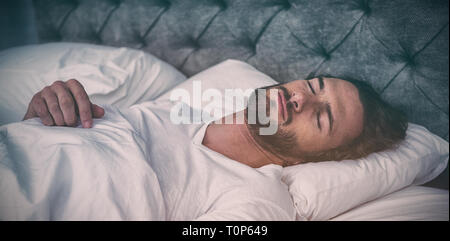 Uomo dorme sul suo letto Foto Stock