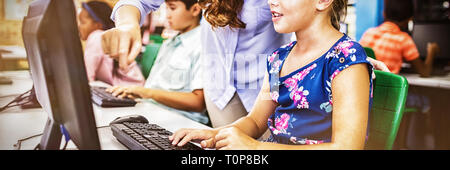 I bambini che cercano i loro computer Foto Stock