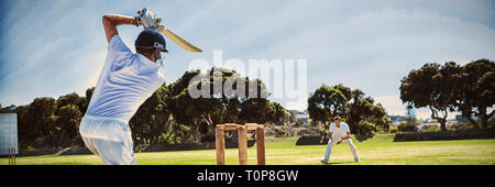 Player batting durante la riproduzione di cricket sul campo Foto Stock