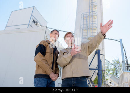 Due lavoratori in fabbrica la discussione all'aperto Foto Stock