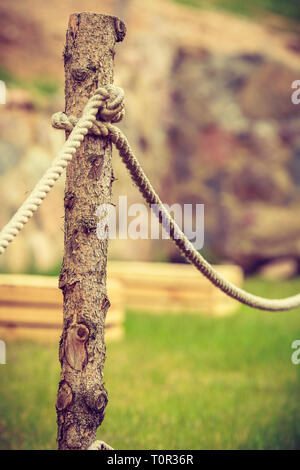 Garden design concept. In vecchio stile recinzione fatta di bastoni e corde di colpo all'aperto. Foto Stock