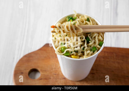 Istante di spaghetti ramen con aroma di carne in un bicchiere di carta, a basso angolo di visione. Close-up. Foto Stock