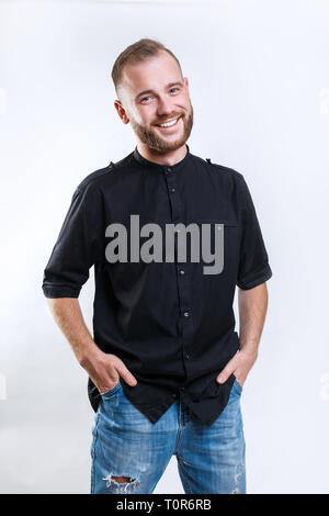 Ritratto di un bel giovane uomo sorridente su sfondo grigio Foto Stock