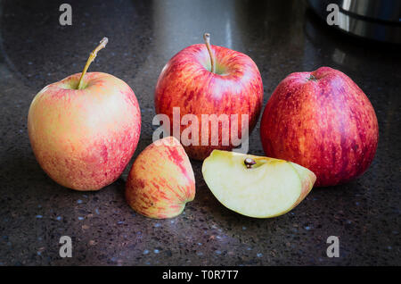 Un gruppo di quattro British-cresciute mature Cameo rosso di mangiare le mele pronto per mangiare Foto Stock