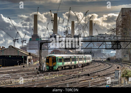 Un treno della Southern Rail che si avvicina a Ebury Bridge sull'approccio finale alla Victoria Station, con la Battersea Power Station in lontananza, Londra, Regno Unito Foto Stock