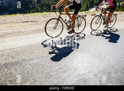 Un uomo e una donna a cavallo di biciclette in montagna. North Cascades autostrada nello Stato di Washington, USA. Autostrada 20. Washington Pass. Foto Stock