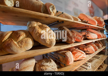 Gli scaffali pieni di pane appena sfornato, in un forno Foto Stock