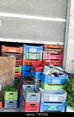 Villaggio Mercato di frutta in cassette di plastica riempiti con erbe al di fuori seduta Foto Stock