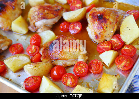 Cosce di pollo con Yukon Gold di patate e di pomodori ciliegini Foto Stock