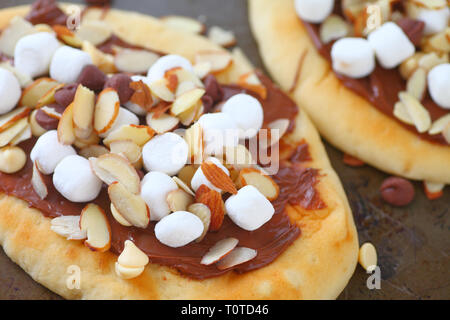 Pizzette con cioccolato da spalmare, marshmallows, scaglie di cioccolato e mandorle Foto Stock