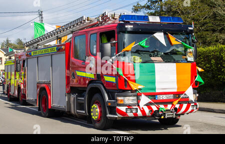 Motore fire prendendo parte a san Patrizio sfilano portando irish bandiera tricolore Foto Stock