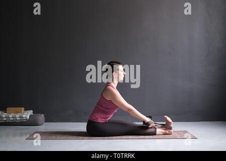 Donna pratica lo yoga, seduti piegare in avanti pone Foto Stock