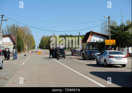 Segno di pericolo e a veicolo in marcia dalla barriera sul punto di attraversamento Dytiatky in cui Chernobyl Zona di esclusione inizia.Il 20 aprile 2018. Dytiatky, Ucraina Foto Stock