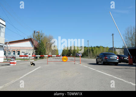 Segno di pericolo e a veicolo in marcia dalla barriera sul punto di attraversamento Dytiatky in cui Chernobyl Zona di esclusione inizia.Il 20 aprile 2018. Dytiatky, Ucraina Foto Stock