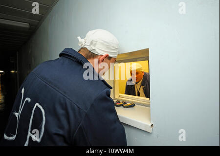 Lavoratore in piedi di fronte a una finestra della radiazione posto di controllo in corrispondenza di un passaggio della centrale nucleare di Cernobyl. Aprile 20,2018. Chernobyl, in Ucraina Foto Stock