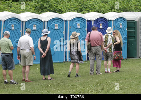 I frequentatori di concerti sono mostrati aspettavano il loro turno in linea durante un concerto all'aperto festival. Foto Stock