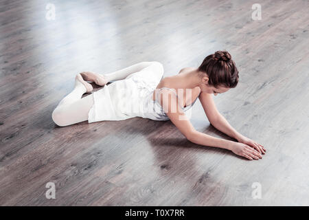 Bella ballerina esperta mettendo i suoi piedi insieme Foto Stock