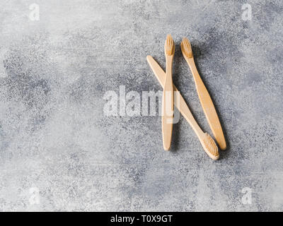 Tre gli spazzolini da denti di bambù su sfondo grigio. Uno stile di vita sostenibile rifiuti zero concetto. No oggetti in plastica. spazio copia Foto Stock