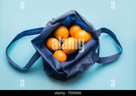 Rifiuti Zero concetto. Blu tessile shopping bag con succo di arancia e verdure. Spazio per il testo. Vista da sopra. Foto Stock