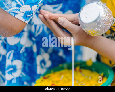 Le persone sono in possesso di una ciotola di acqua con il profumo dei fiori per la preparazione di doccia per i monaci su Songkran giorno.(THAILANDIA ANNO NUOVO) Foto Stock