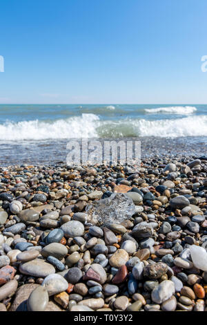 Spiaggia di ciottoli lungo la costa del lago michigan. Inizio primavera/fine inverno. Racine, Wisconsin. Foto Stock