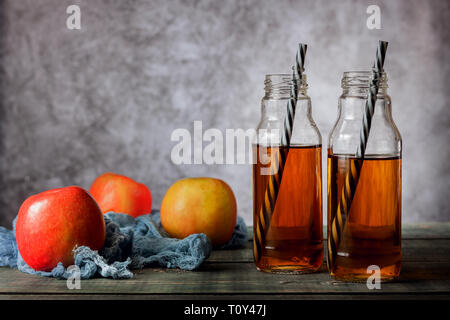 Sul tavolo sono le mele e spremuta fresca in una bottiglia di vetro Foto Stock