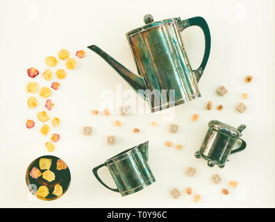 Vintage set per il tè e caffè con petali di rosa su sfondo chiaro. Foto Stock