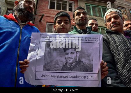 Srinagar Kashmir. Xxii marzo, 2019. - Un dimostrante visto tenendo un poster foto con un'immagine di Rizwan Pandit durante la protesta.i sostenitori del Jammu Kashmir Liberation Front JKLF terrà una manifestazione di protesta contro la morte di un insegnante della scuola in custodia della polizia dopo che egli è stato arrestato in connessione con un terrore caso inchiesta. Credito: Saqib Majeed SOPA/images/ZUMA filo/Alamy Live News Foto Stock