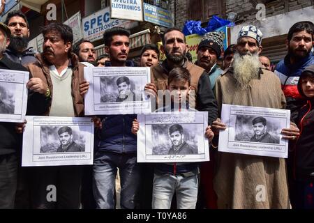 Srinagar Kashmir. Xxii marzo, 2019. - I dimostranti visto azienda foto poster con un'immagine di Rizwan Pandit durante la protesta.i sostenitori del Jammu Kashmir Liberation Front JKLF terrà una manifestazione di protesta contro la morte di un insegnante della scuola in custodia della polizia dopo che egli è stato arrestato in connessione con un terrore caso inchiesta. Credito: Saqib Majeed SOPA/images/ZUMA filo/Alamy Live News Foto Stock