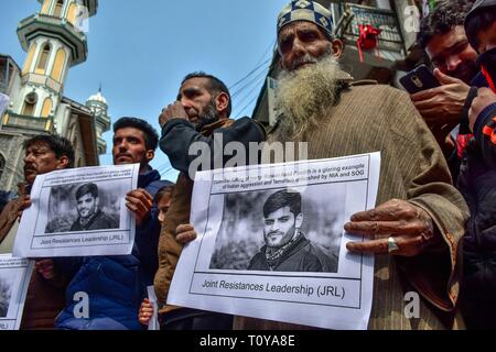 Srinagar Kashmir. Xxii marzo, 2019. - I dimostranti visto azienda foto poster con un'immagine di Rizwan Pandit durante la protesta.i sostenitori del Jammu Kashmir Liberation Front JKLF terrà una manifestazione di protesta contro la morte di un insegnante della scuola in custodia della polizia dopo che egli è stato arrestato in connessione con un terrore caso inchiesta. Credito: Saqib Majeed SOPA/images/ZUMA filo/Alamy Live News Foto Stock