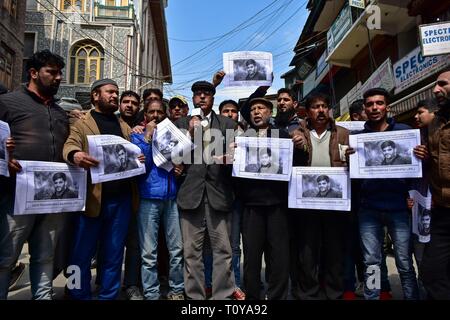 Srinagar Kashmir. Xxii marzo, 2019. - I dimostranti visto azienda foto poster con un'immagine di Rizwan Pandit durante la protesta.i sostenitori del Jammu Kashmir Liberation Front JKLF terrà una manifestazione di protesta contro la morte di un insegnante della scuola in custodia della polizia dopo che egli è stato arrestato in connessione con un terrore caso inchiesta. Credito: Saqib Majeed SOPA/images/ZUMA filo/Alamy Live News Foto Stock