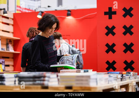 Leipzig, Germania. Xxi Mar, 2019. Un visitatore legge un libro in corrispondenza di una parte della cabina della Svizzera durante il 2019 Lipsia Fiera del Libro di Lipsia, Germania, 21 marzo 2019. Quattro giorni di Leipzig Book Fair ha dato dei calci a fuori di giovedì, che attrae oltre 2.500 espositori provenienti da più di cinquanta paesi e regioni di tutto il mondo. Credito: Kevin Voigt/Xinhua/Alamy Live News Foto Stock