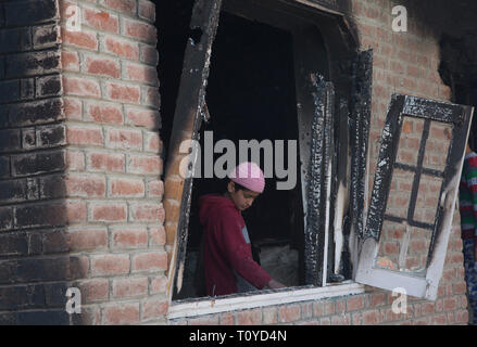 Srinagar Kashmir. 22 Mar, 2019. Un ragazzo ispeziona un olocausto finestra di una casa distrutta in uno scontro a fuoco a Hajin villaggio del distretto di Bandipora, circa 40 km a nord di Srinagar, la capitale estiva del Kashmir, Marzo 22, 2019. Sei militanti e un 12-anno-vecchio ragazzo sono stati uccisi in tre distinte sparatorie feroci in irrequieta Kashmir, funzionari detto venerdì. Credito: Javed Dar/Xinhua/Alamy Live News Foto Stock