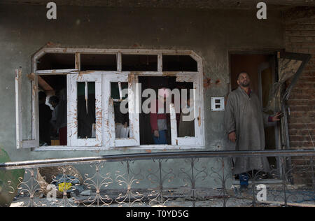 Srinagar Kashmir. 22 Mar, 2019. Persone ispezionare una casa danneggiata in uno scontro a fuoco a Hajin villaggio del distretto di Bandipora, circa 40 km a nord di Srinagar, la capitale estiva del Kashmir, Marzo 22, 2019. Sei militanti e un 12-anno-vecchio ragazzo sono stati uccisi in tre distinte sparatorie feroci in irrequieta Kashmir, funzionari detto venerdì. Credito: Javed Dar/Xinhua/Alamy Live News Foto Stock