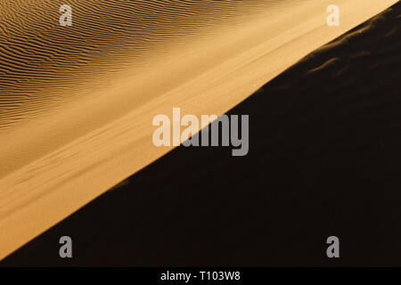 Le grandi dune di sabbia di Erg Chebbi, Marocco, offrono una splendida vista di onde e forme e modifica di golden, rosso e arancione durante il tramonto e sunse Foto Stock