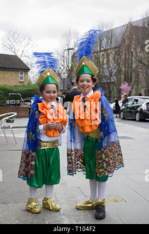 Due ragazze Hasidic sorridente in costume per la festa ebraica di Purim il 21 marzo 2019 su angolo di strada a Stamford Hill Londra Foto Stock