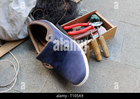 Le attrezzature utilizzate per le operazioni manuali di suola di calzatura sticthing memorizzato in un carrello di legno. Foto Stock