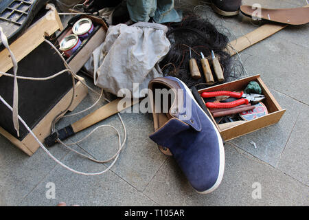 Le attrezzature utilizzate per le operazioni manuali di suola di calzatura sticthing memorizzato in un carrello di legno. Foto Stock