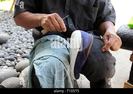 Processo di scarpa manuale Riparazione, suola e welt di fissaggio e di cucitura. Preso in Indonesia. Foto Stock