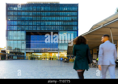 Montpellier (sud della Francia): il municipio progettato dagli architetti Jean Nouvel e Francois Fontes. Due persone visto da dietro camminando sulla squ Foto Stock