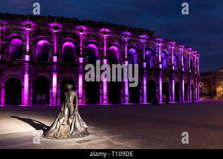 Nimes (sud-est della Francia): l'Arena al calar della sera con una statua di Christian Montcouquiol ("Nimeno II ") e le luci di Natale Foto Stock