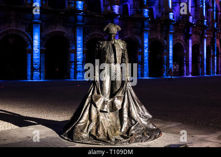 Nimes (sud-est della Francia): l'Arena al calar della sera con una statua di Christian Montcouquiol ("Nimeno II ") e le luci di Natale Foto Stock