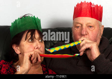 Coppia di anziani che indossa la carta Christmas Cracker cappelli Foto Stock